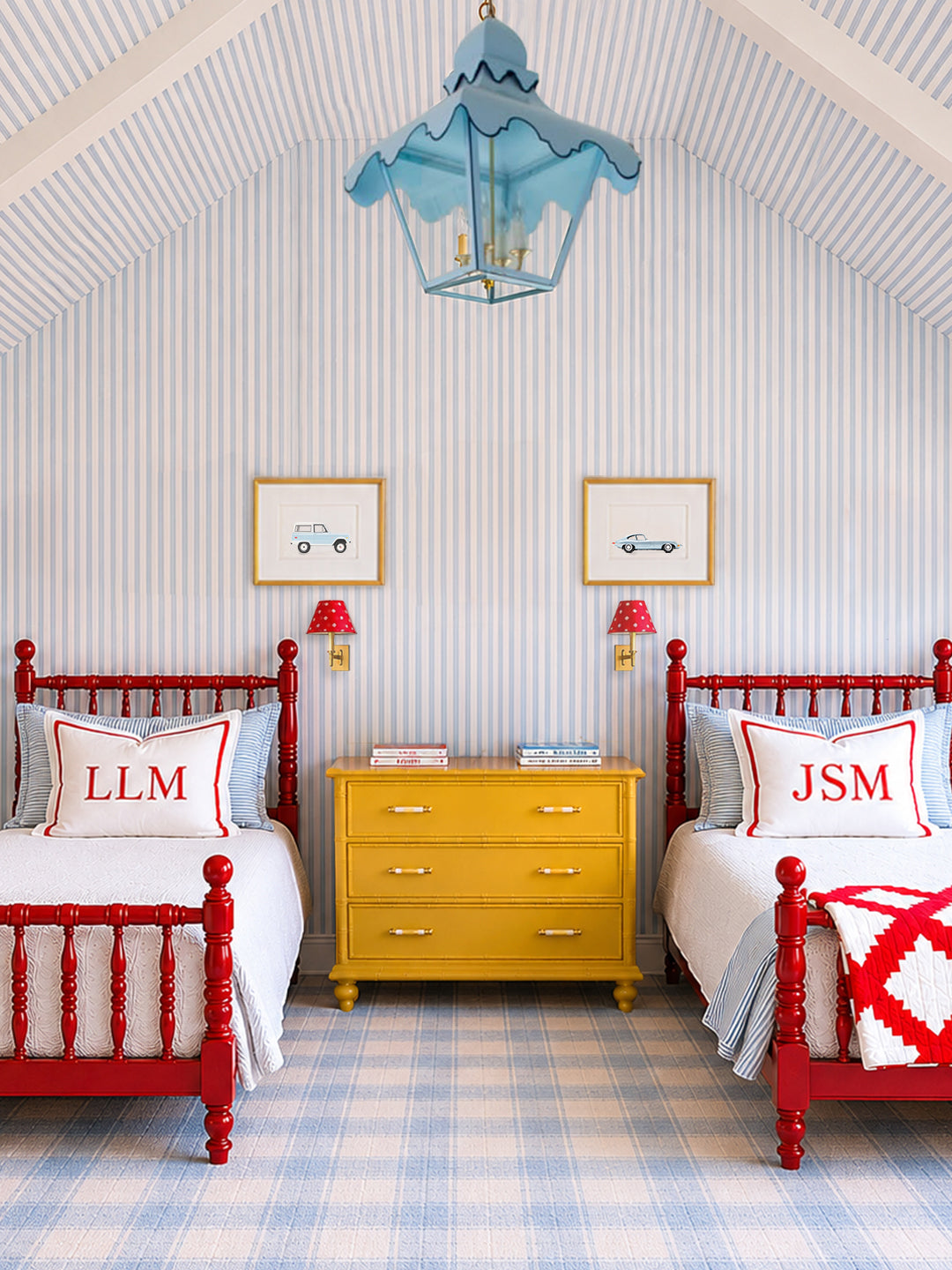 Boys twin bedroom with vintage car print artwork, red beds, yellow dresser, and striped wallpaper. 