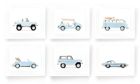A gallery wall set of six vintage classic car art prints in powder blue on a white background, featuring a Ford Bronco, Fiat Jolly, and VW Bus, styled for a sophisticated boy’s nursery or playroom.